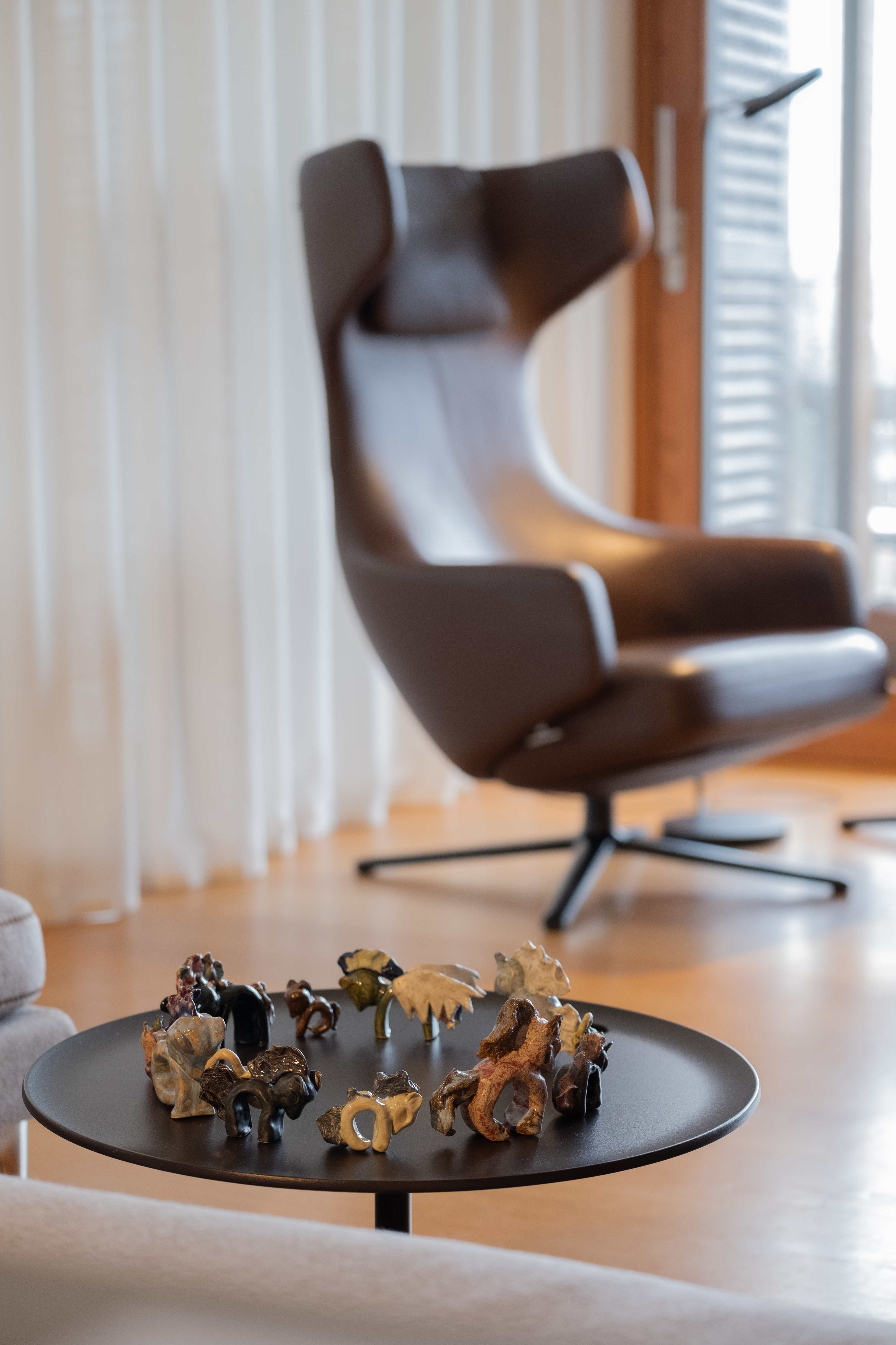 a chair and small table on which sits a circle of toy horses