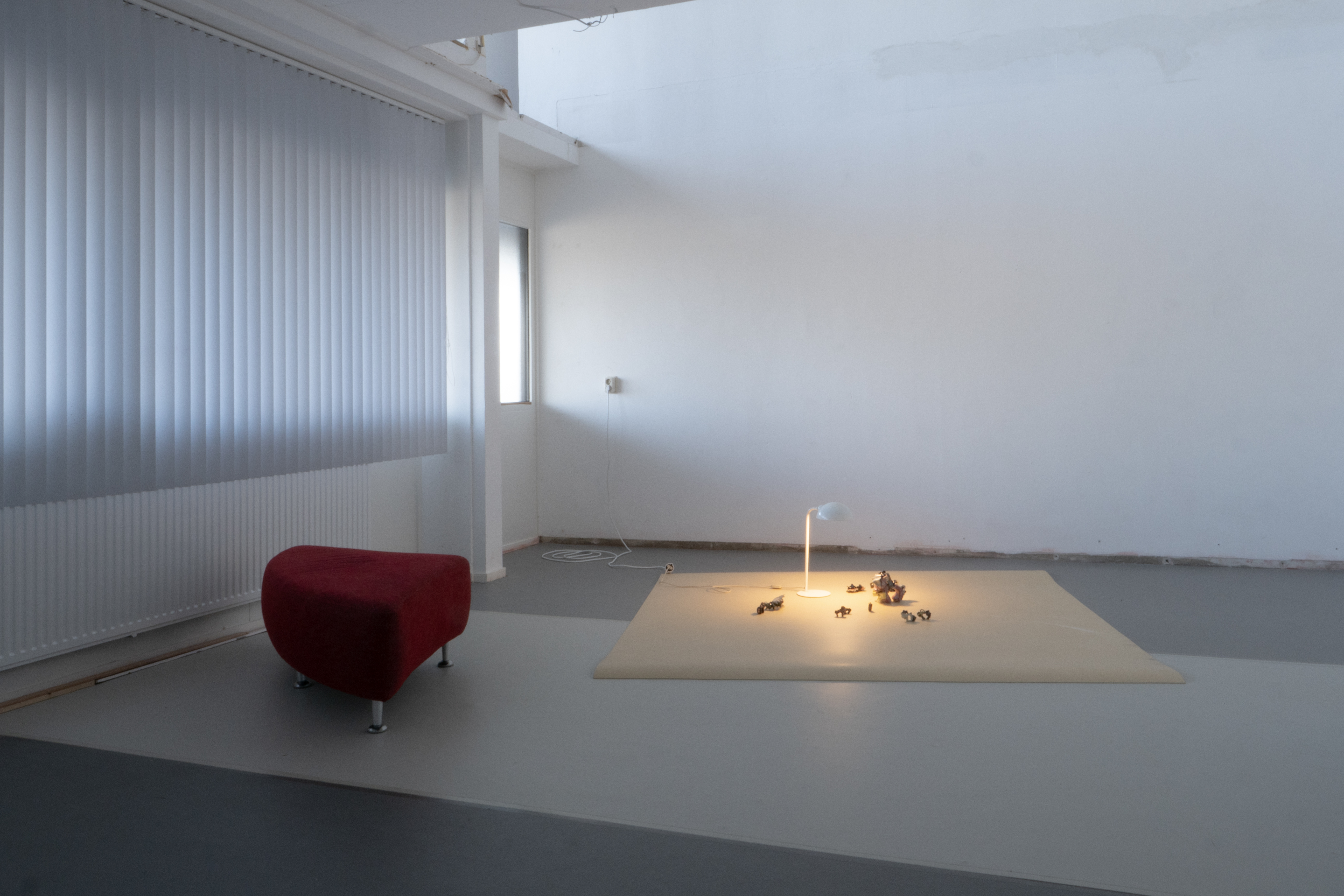 a red bench, a white lamp, ceramic horses and marmoleum